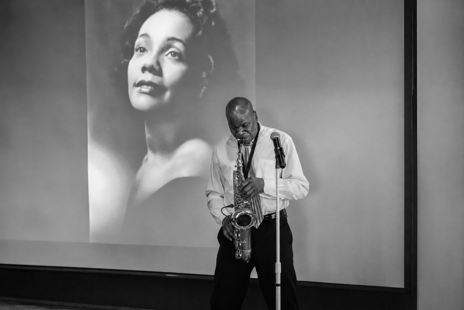 Saxophonist performing at the Coretta Scott King banquet beneath a projected portrait